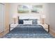 This bedroom features a window with blinds, two framed pictures, lamps on two end tables, and a door at 2928 Buccaneer Palm Rd, Kissimmee, FL 34747