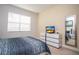 This bedroom features a window with blinds, a dresser with a TV, and a mirror at 2928 Buccaneer Palm Rd, Kissimmee, FL 34747