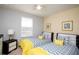 Twin bedroom featuring bright yellow accents, ceiling fan, and comfortable accommodations at 2928 Buccaneer Palm Rd, Kissimmee, FL 34747