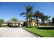 Community clubhouse exterior featuring lush landscaping, palm trees, and a well-manicured lawn at 2928 Buccaneer Palm Rd, Kissimmee, FL 34747