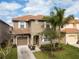 Charming two-story home with a tile roof, well-manicured lawn, and an attached one car garage at 2928 Buccaneer Palm Rd, Kissimmee, FL 34747