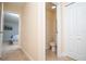 Bright hallway featuring neutral walls, tile flooring, and doors leading to a bedroom and half bathroom at 2928 Buccaneer Palm Rd, Kissimmee, FL 34747