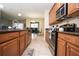 This kitchen features hardwood cabinets, a bar with chairs, tile flooring, and stainless steel appliances at 2928 Buccaneer Palm Rd, Kissimmee, FL 34747
