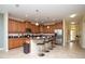 This kitchen features hardwood cabinets, a bar with chairs, tile flooring, and stainless steel appliances at 2928 Buccaneer Palm Rd, Kissimmee, FL 34747