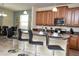 This kitchen features hardwood cabinets, a bar with chairs, tile flooring, and stainless steel appliances at 2928 Buccaneer Palm Rd, Kissimmee, FL 34747