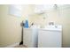 This laundry room features a window with blinds, a clothes rack, a washing machine, and a dryer at 2928 Buccaneer Palm Rd, Kissimmee, FL 34747