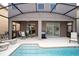 Covered patio featuring an outdoor dining set and sliding glass doors to the home's interior at 2928 Buccaneer Palm Rd, Kissimmee, FL 34747