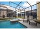 Screened-in pool area with a spa, lounge chairs, and views of the surrounding properties at 2928 Buccaneer Palm Rd, Kissimmee, FL 34747