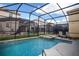 A stunning screened-in pool and jacuzzi surrounded by lush green landscaping and neighboring properties at 2928 Buccaneer Palm Rd, Kissimmee, FL 34747