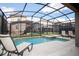 Private screened-in pool and spa area surrounded by lush landscaping and comfortable seating at 2928 Buccaneer Palm Rd, Kissimmee, FL 34747