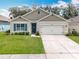 Charming single-story home boasts a well-manicured lawn, lovely landscaping, and a two-car garage at 29746 Anahid Dr, Leesburg, FL 34748