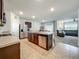 Open-concept kitchen with stainless steel appliances and an island with barstool seating that opens to the living room at 29746 Anahid Dr, Leesburg, FL 34748