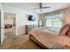 Spacious main bedroom features a ceiling fan, TV, and access to the en-suite bath and walk-in closet at 29746 Anahid Dr, Leesburg, FL 34748