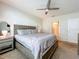 Bright bedroom boasts a large bed, ceiling fan, and access to the en-suite bathroom at 29746 Anahid Dr, Leesburg, FL 34748