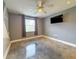 Bedroom with gray walls, a ceiling fan, and a mounted television at 3034 Parkway Blvd # 102, Kissimmee, FL 34747