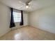 Bedroom with tile flooring, a ceiling fan, and a window with curtains at 3034 Parkway Blvd # 102, Kissimmee, FL 34747