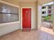 Close up of red front door and welcome mat, inviting entrance to the residence at 3034 Parkway Blvd # 102, Kissimmee, FL 34747