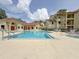 Community pool featuring a refreshing blue color with lounge seating, jacuzzi, and clubhouse at 3034 Parkway Blvd # 102, Kissimmee, FL 34747