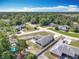 Aerial view of the property showcasing the neighborhood, mature trees and nearby pond at 3130 Clewiston St, Deltona, FL 32738