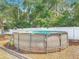 Above-ground pool nestled in a backyard setting with surrounding trees and a privacy fence at 3130 Clewiston St, Deltona, FL 32738