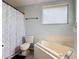 Bright bathroom features a tub, toilet, shower, and window at 3130 Clewiston St, Deltona, FL 32738