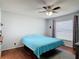 Bedroom featuring wood floors, a ceiling fan, and a large window with patterned curtains at 3130 Clewiston St, Deltona, FL 32738