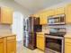 Modern kitchen featuring stainless steel appliances and wood-toned cabinets for a warm and inviting feel at 3130 Clewiston St, Deltona, FL 32738
