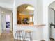 View of kitchen pass-through with stools, wood cabinets, and a view of another room at 3130 Clewiston St, Deltona, FL 32738