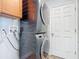Laundry area includes modern stacked washer and dryer with light wood cabinets at 3130 Clewiston St, Deltona, FL 32738