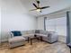 Spacious living room features wood-look floors, a ceiling fan, and large sectional sofa at 3130 Clewiston St, Deltona, FL 32738