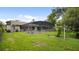 Backyard view of a screened pool area with lush green lawn and landscaping at 316 Cambridge Dr, Longwood, FL 32779