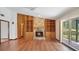 Inviting living room with wood floors, stone fireplace, and custom built-in shelving at 316 Cambridge Dr, Longwood, FL 32779