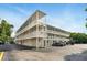 Condo building with three stories, exterior staircases, parking, and white facade at 320 Lakeview St # 220, Orlando, FL 32804