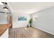 Open-concept living space with wood floors, city artwork, and a large window at 320 Lakeview St # 220, Orlando, FL 32804