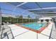 A screened in pool with red brick edging has white lounge chairs and hedges with lush greenery at 320 Lakeview St # 220, Orlando, FL 32804