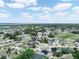 Aerial view of neighborhood featuring lush green trees and a variety of single-Gathering homes with vibrant blue skies at 331 Erie Ct, Kissimmee, FL 34759