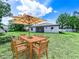 Charming backyard featuring a wooden dining table with umbrella, perfect for outdoor entertaining at 331 Erie Ct, Kissimmee, FL 34759