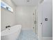 Bright bathroom with standalone tub, shower with glass door, and textured wall tiles at 331 Erie Ct, Kissimmee, FL 34759