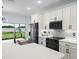 Modern kitchen with stainless steel appliances, white cabinets, quartz countertops, tile backsplash, and a kitchen island at 331 Erie Ct, Kissimmee, FL 34759
