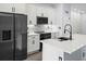 Modern kitchen with stainless steel appliances, white cabinets, and an island with black faucet at 331 Erie Ct, Kissimmee, FL 34759