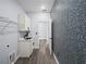 Laundry room features white cabinets, black fixtures, and unique mosaic wall tile at 331 Erie Ct, Kissimmee, FL 34759