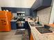 Stylish kitchen featuring stainless steel appliances, navy cabinets, and quartz countertops at 3391 S Kirkman Rd # 1236, Orlando, FL 32811