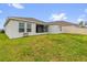 View of the home's exterior with a screened in lanai and spacious backyard at 3405 Yarian Dr, Haines City, FL 33844