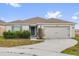 Charming single-story home featuring a two-car garage, landscaped yard, and neutral-toned facade at 3405 Yarian Dr, Haines City, FL 33844