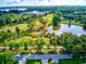 Beautiful aerial view of a golf course pond, with lush greenery and surrounding residential area under a sunny sky at 3460 Fairway Ln, Orlando, FL 32804