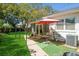 Spacious backyard featuring lush green grass, covered patio area, and a table with umbrella for outdoor dining at 3460 Fairway Ln, Orlando, FL 32804