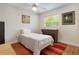Cozy bedroom featuring hardwood floors, natural light, and a charming single bed with a red patterned rug at 3460 Fairway Ln, Orlando, FL 32804