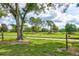 Picturesque view of the golf course featuring lush green grass, mature trees, and a serene pond under a partly cloudy sky at 3460 Fairway Ln, Orlando, FL 32804