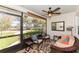 Relaxing screened porch with wicker furniture, ceiling fan, and a view of the beautifully landscaped yard at 3460 Fairway Ln, Orlando, FL 32804
