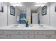 Bright bathroom featuring a double sink vanity and large mirror at 4816 Tidecrest Ave # 178, Orlando, FL 32819
